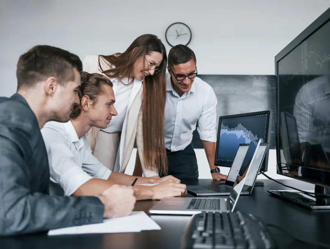 Gatblac team reviewing market charts on several screens